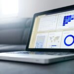 分析ダッシュボードのグラフを表示したノートPC。観光統計・データ活用のイメージ