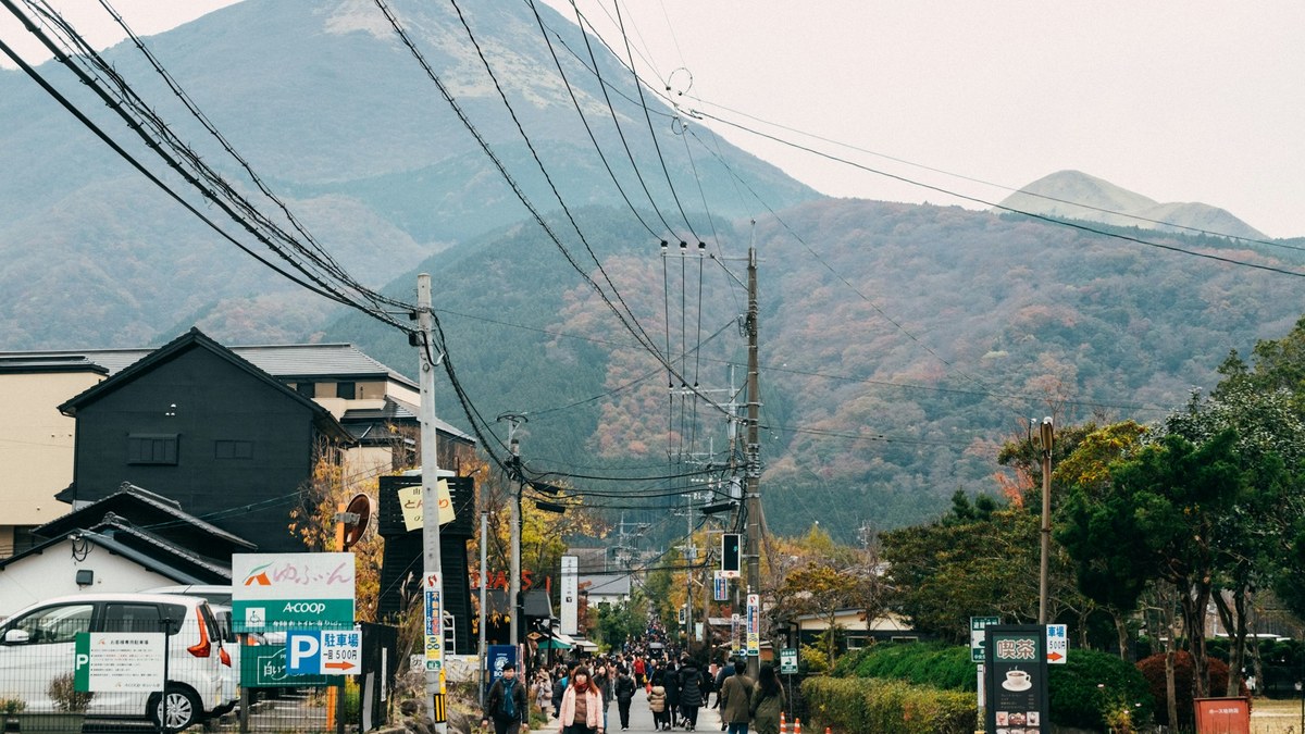 由布院の街並みと由布岳を望む通りを歩く旅行者