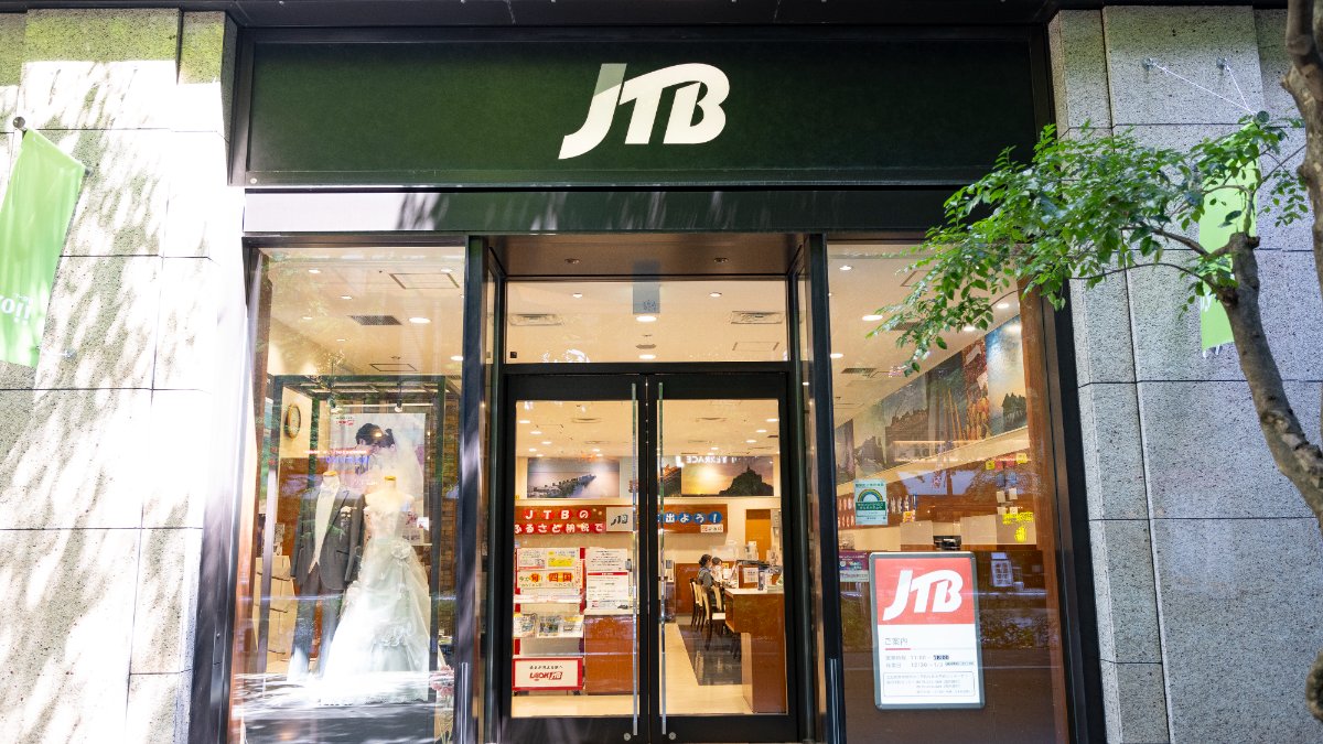 「JTB」の看板を掲げた旅行会社店舗の入口