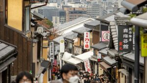 土産物店が並ぶ石畳の坂道を大勢の観光客が歩く