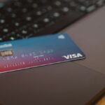 ノートPCのキーボードの上に置かれたクレジットカード。オンライン決済のイメージ