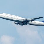 青空を上昇する4発エンジンの大型旅客機