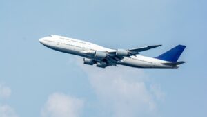 青空を上昇する4発エンジンの大型旅客機