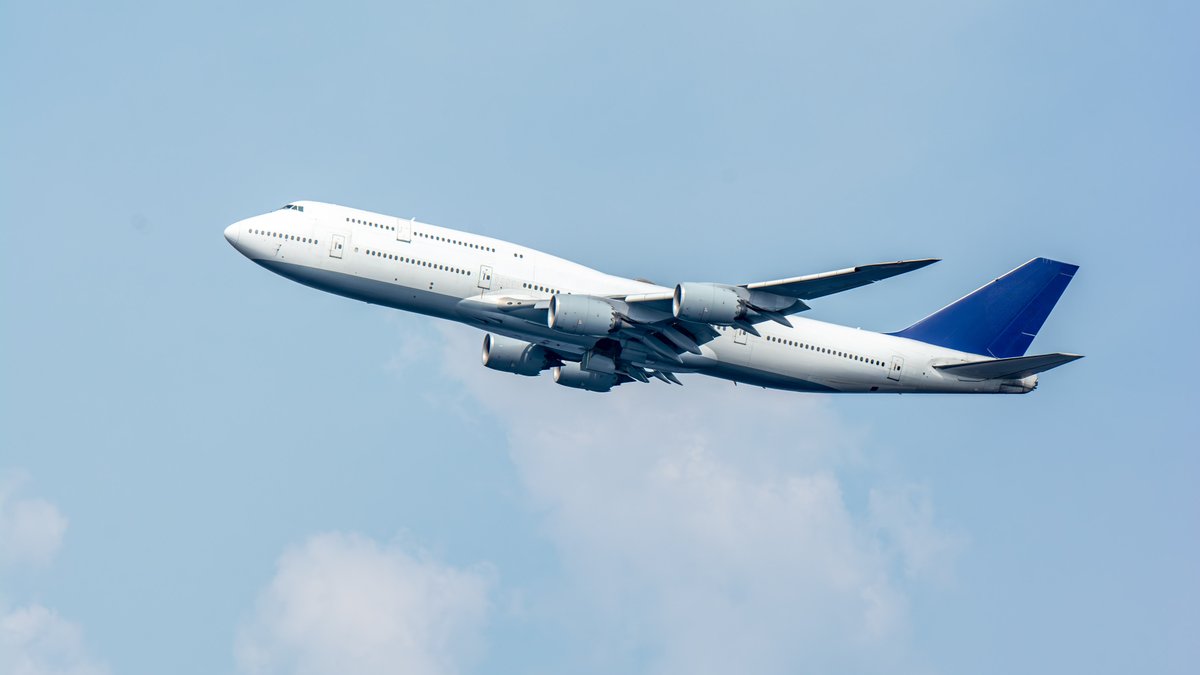 青空を上昇する4発エンジンの大型旅客機