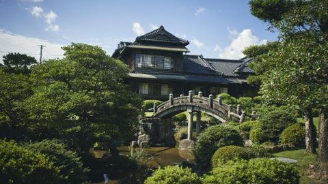 池と石橋のある庭園から望む旧伊藤伝右衛門邸