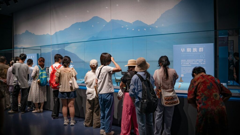 展示ケースを取り囲み、収蔵品を覗き込む来館者たち