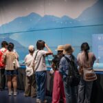 展示ケースを取り囲み、収蔵品を覗き込む来館者たち