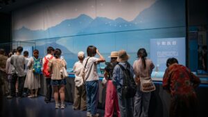 展示ケースを取り囲み、収蔵品を覗き込む来館者たち