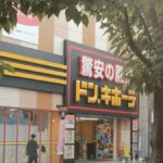 街路樹越しに見たドン・キホーテの店舗外観。入り口の脇に免税（Tax Free）の案内が出ている
