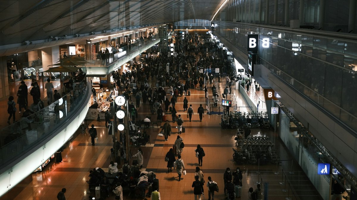 空港ターミナルの出発ロビーを行き交う大勢の旅行者