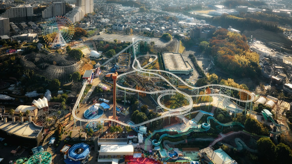 住宅地に囲まれた遊園地を上空から見たところ。観覧車、木製コースター、鋼製のジェットコースター、ウォータースライダーが一つの敷地に並ぶ。