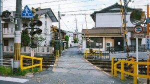 住宅街の中を通る線路の踏切と遮断機