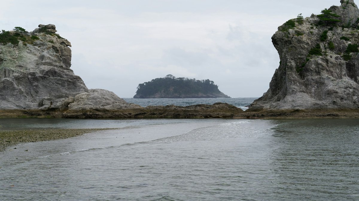 岩手県宮古市の浄土ヶ浜。白い岩壁に挟まれた入り江の奥に小島が浮かぶ